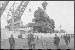 Lasting av det norske skipet M/S Montevideo i New York, 1943. Lasten besto av lokomotiver og fly, samt 400 tonn T.N.T. Foto: Ole Friele Backer.