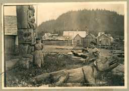 Unge jenter tilhøyrande urbefolkning, truleg tlingitane, ved totempæler i Wrangell, Alaska.  Foto: Arthur C. Pillsbury
