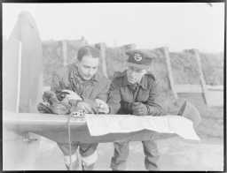 To norske squadrons med norske bakkemannskaper under kommando av Second Tactical Air Force opererer i første linje på Vestfronten. Norske flygere utfører som fighter- og fighter bomber-piloter daglige sweep over fiendtlig område. En flyger diskuterer dagens operasjon med intelligensoffiseren.(Original bildetekst). Foto: Mattis Mathiesen.