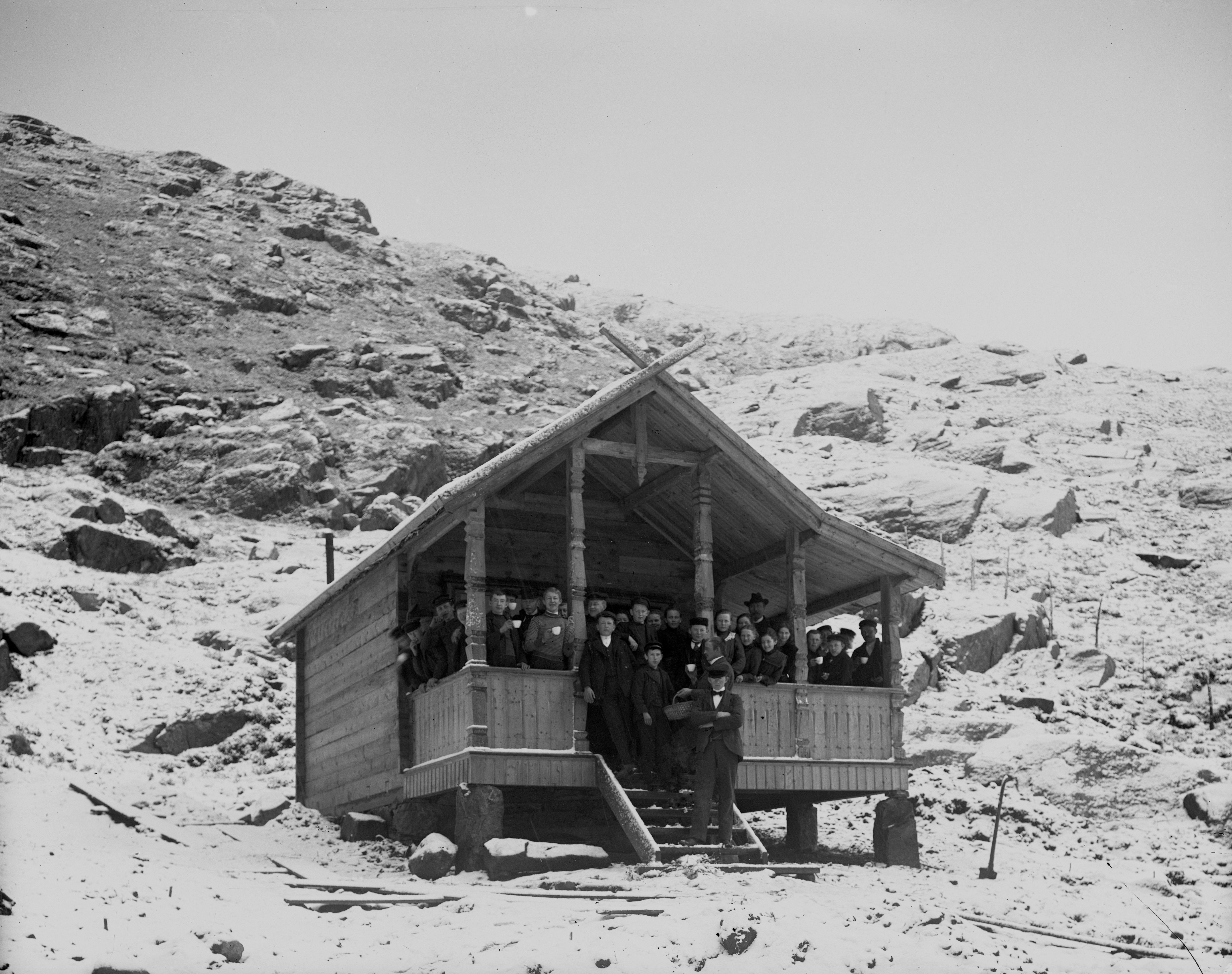 Figur 3 Nysnø og første plantedag på Orkjå i mai 1903. Skoleelever på verandaen i Severin Malmins nybygde hytte.