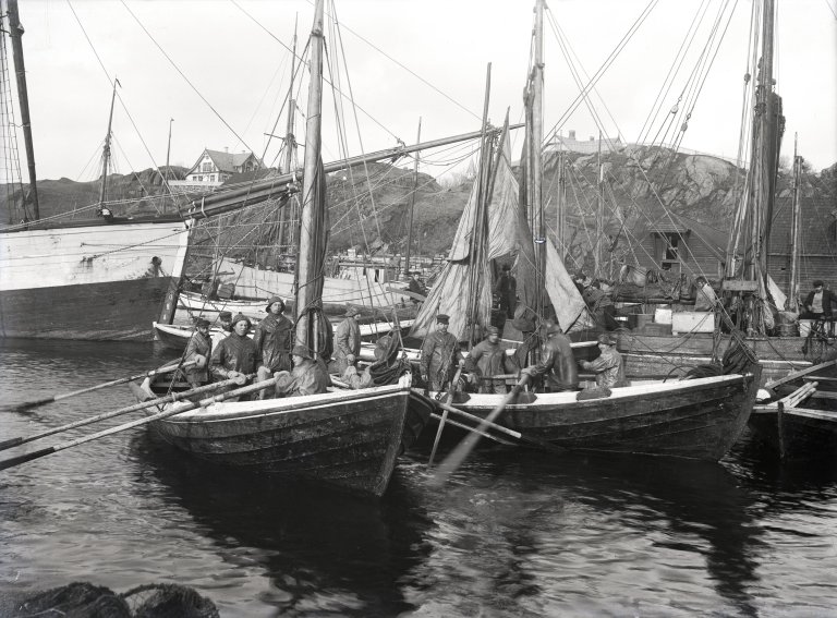 Utsnitt som viser fiskebåter ved Havnaberg i Haugesund. Tårnet på Skåre kirke kan skimtes mellom mastene.