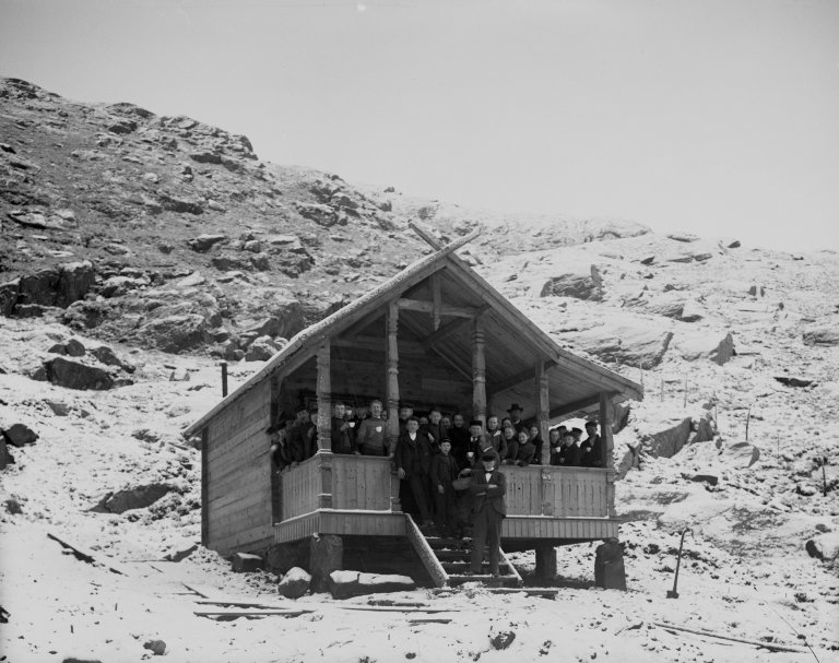 Figur 3 Nysnø og første plantedag på Orkjå i mai 1903. Skoleelever på verandaen i Severin Malmins nybygde hytte.