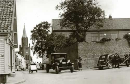 Amtssjukehuset på St. Pedersgjerde bak det høge gjerdet til høgre. Den store to-etasjes trebygningen vart fotografert om lag 1930 før han skulle rivast for å gje plass til Stavanger Tinghus. Sjukehuset låg til Bergelandsgata og hadde St. Petri kirke i nabolaget. Dette første fylkeskommunale sjukehuset vart ferdig i 1843 og var sjukehuset til folk på landsbygda i heile fylket fram til det nye Rogaland Sjukehus stod ferdig i 1927. Foto: G. Wareberg. Statsarkivet i Stavanger.